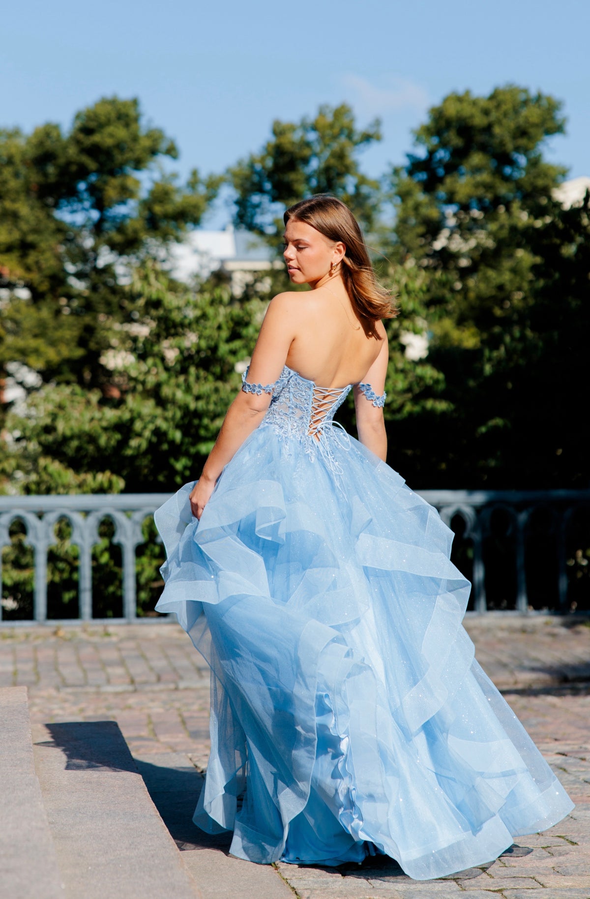 Sininen vanhojentanssimekko off shoulder -yläosalla ja röyhelöhelmalla.