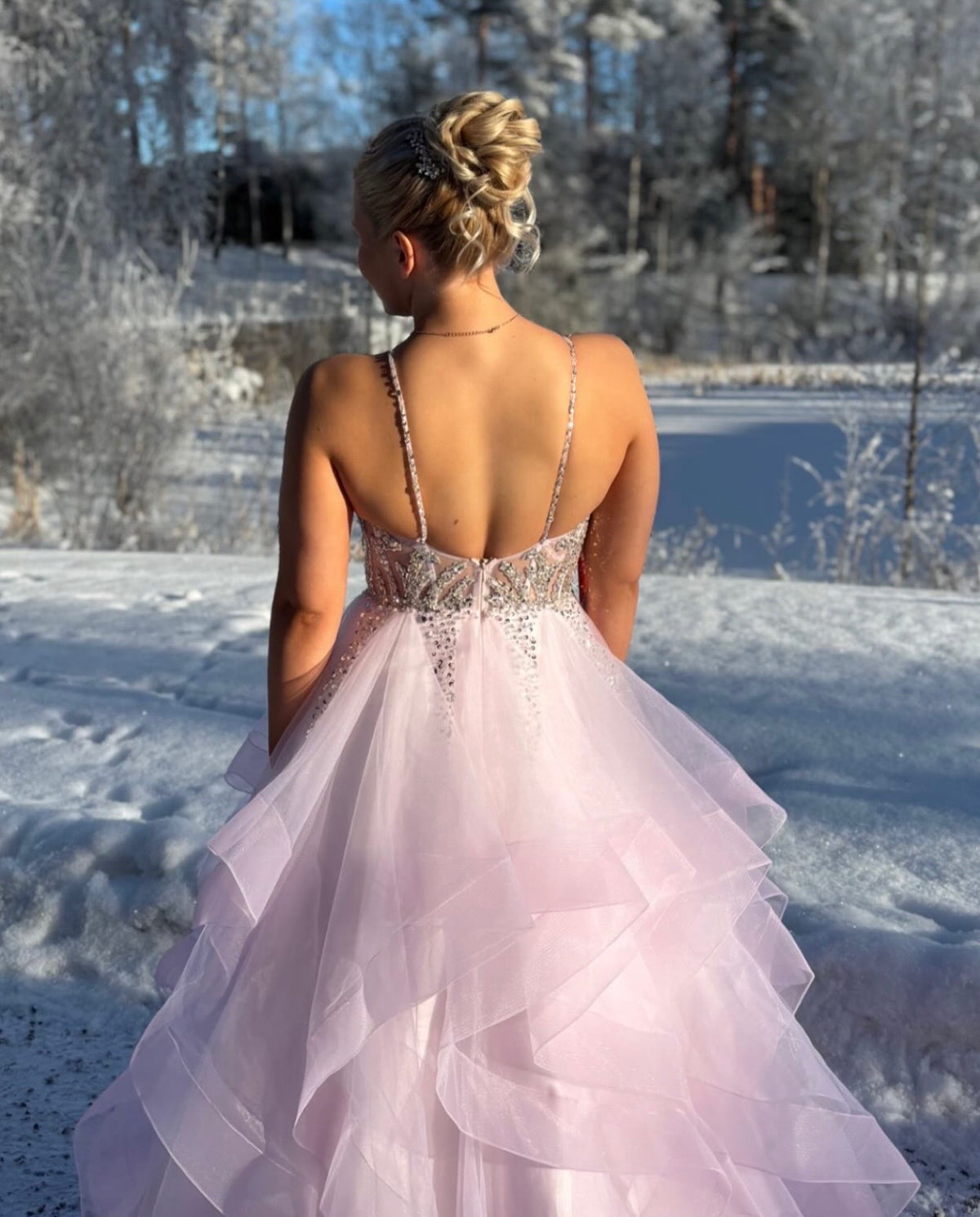 Vaaleapunainen röyhelöhelmainen vanhojentanssimekko.