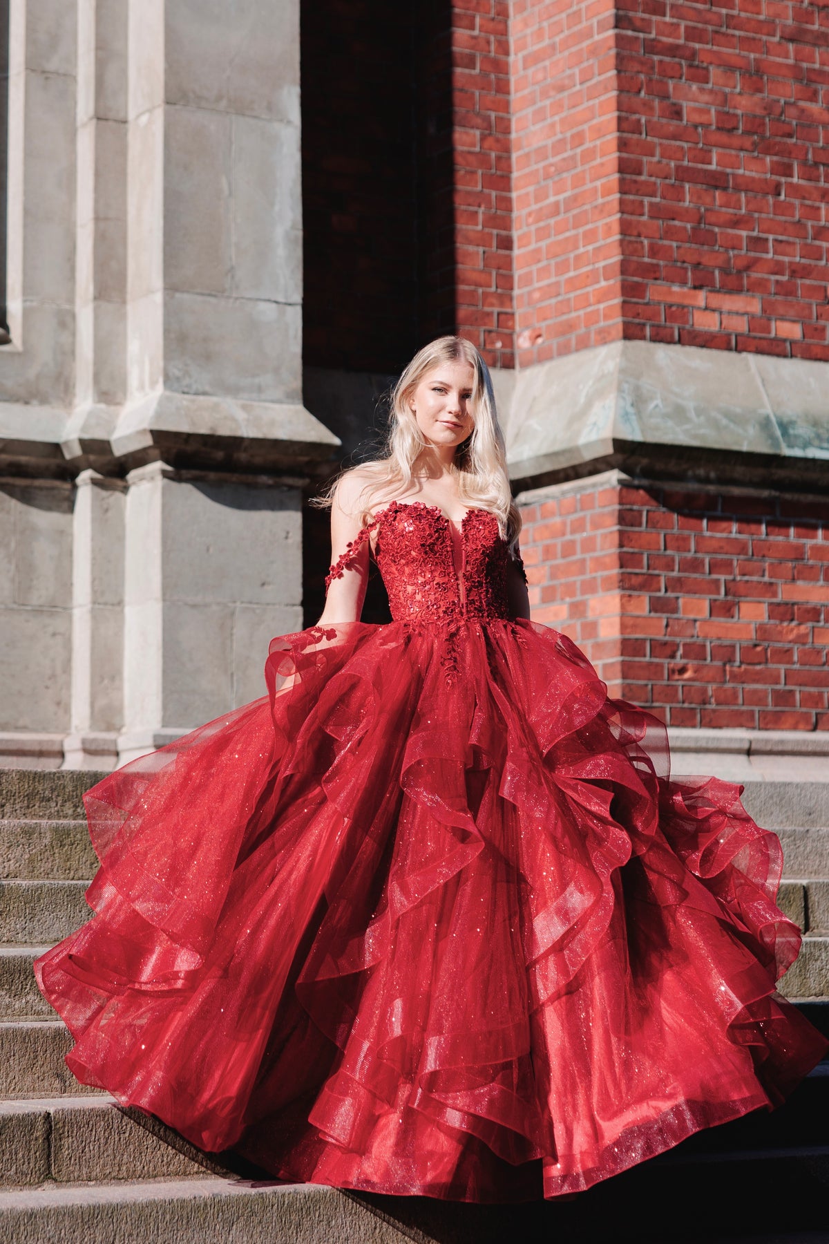 Tummanpunainen vanhojentanssimekko röyhelöhelmalla ja off shoulder olkaimilla.