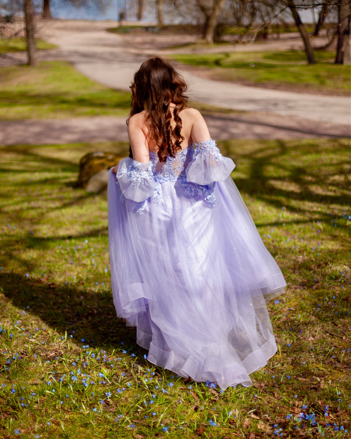 Violetti vanhojentanssimekko tyllistä, off shoulder -olkaimet ja ilmava helma, takaa.