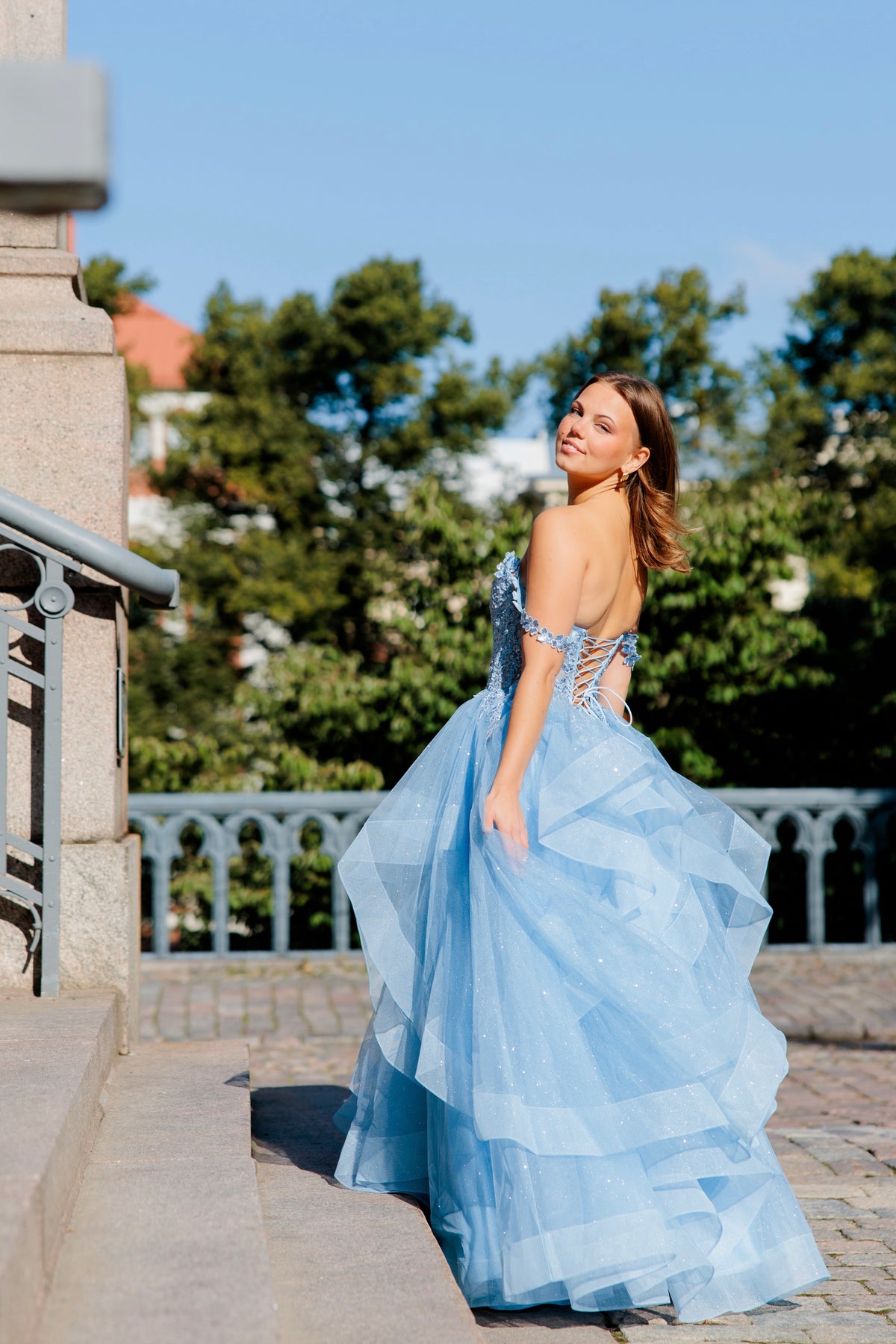 Sininen vanhojentanssimekko off shoulder -yläosalla ja röyhelöhelmalla.