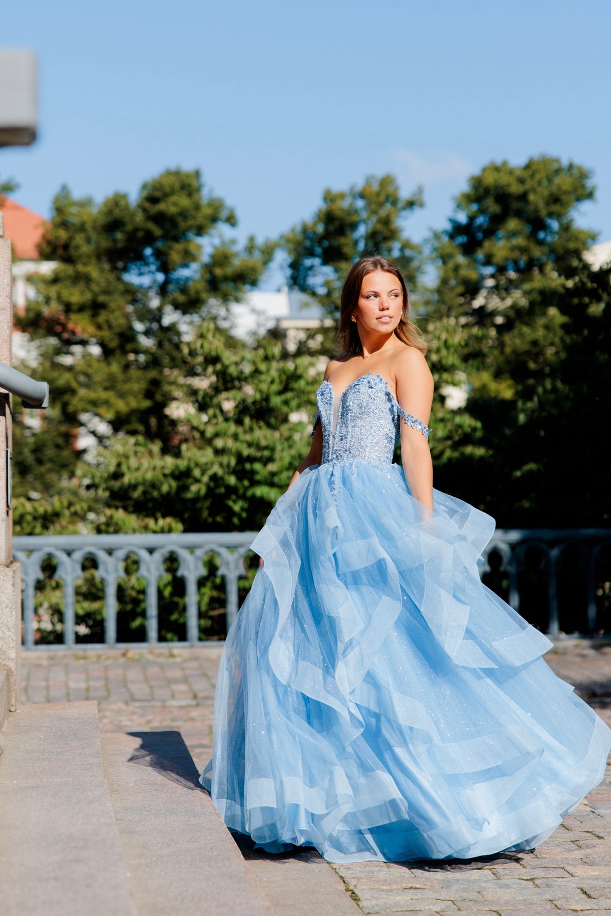 Sininen vanhojentanssimekko off shoulder -yläosalla ja röyhelöhelmalla.