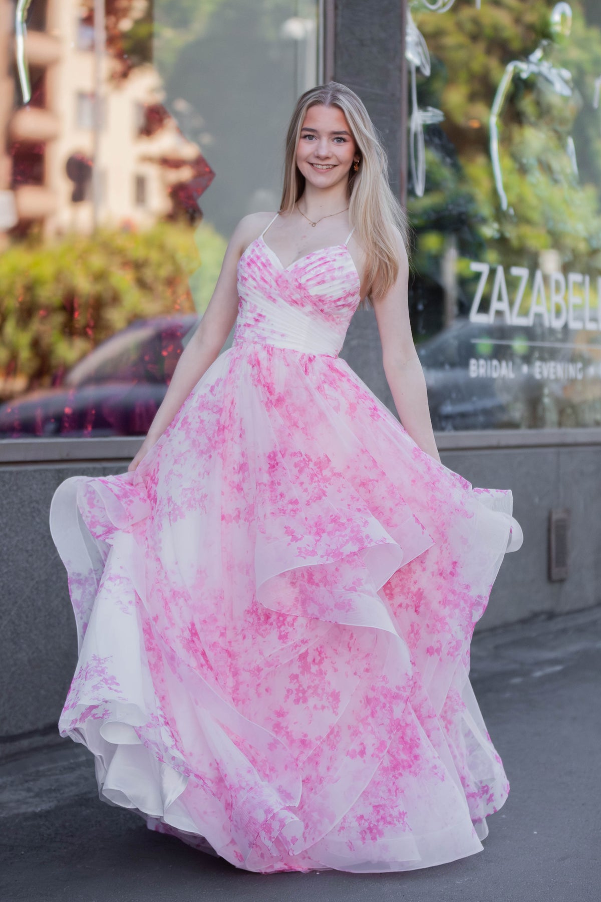 Pinkkivalkoinen vanhojentanssimekko röyhelöhelmalla ja avoimella selällä. 