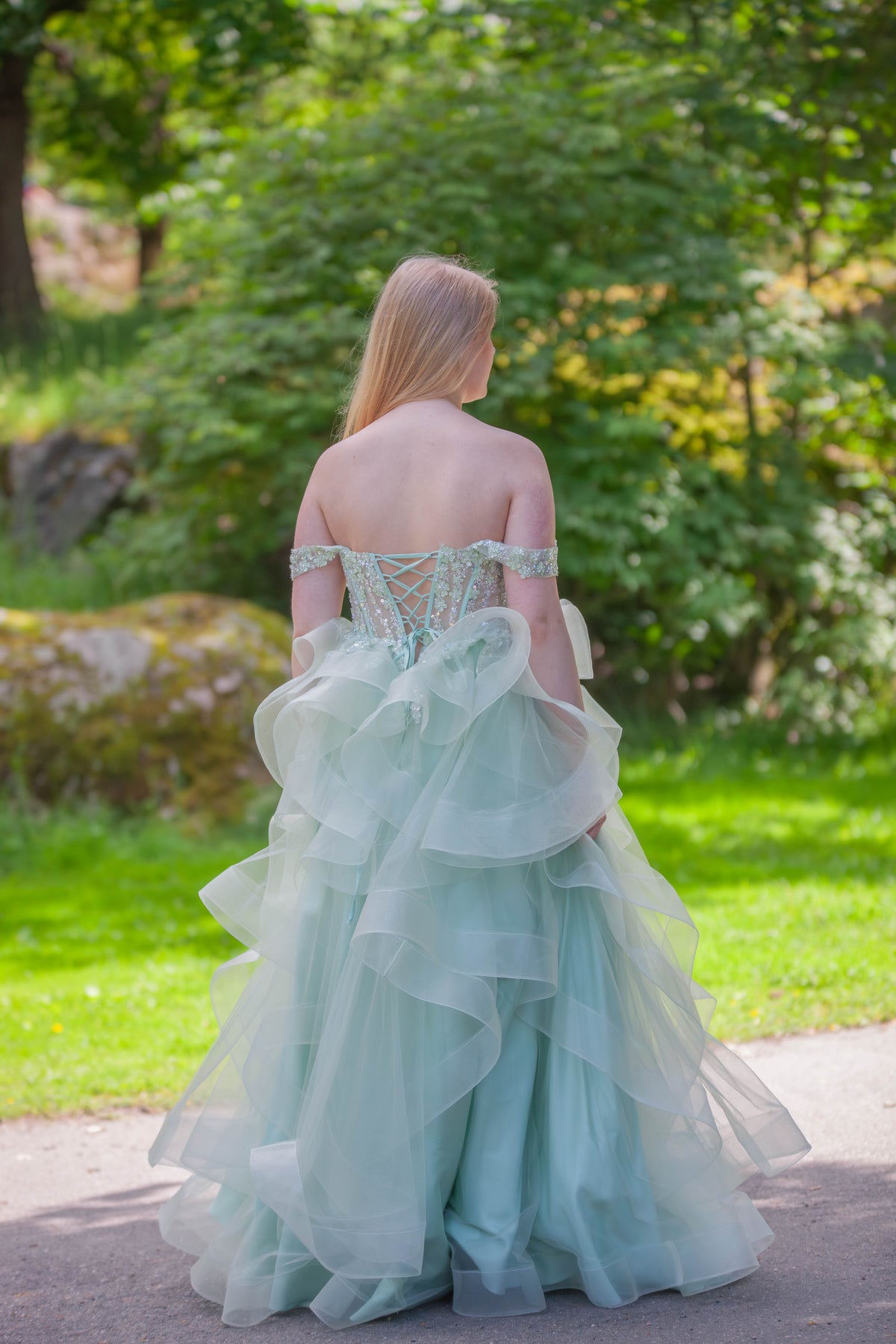 Vaaleanvihreä vanhojentanssimekko röyhelöhelmalla ja off shoulder -mallilla.