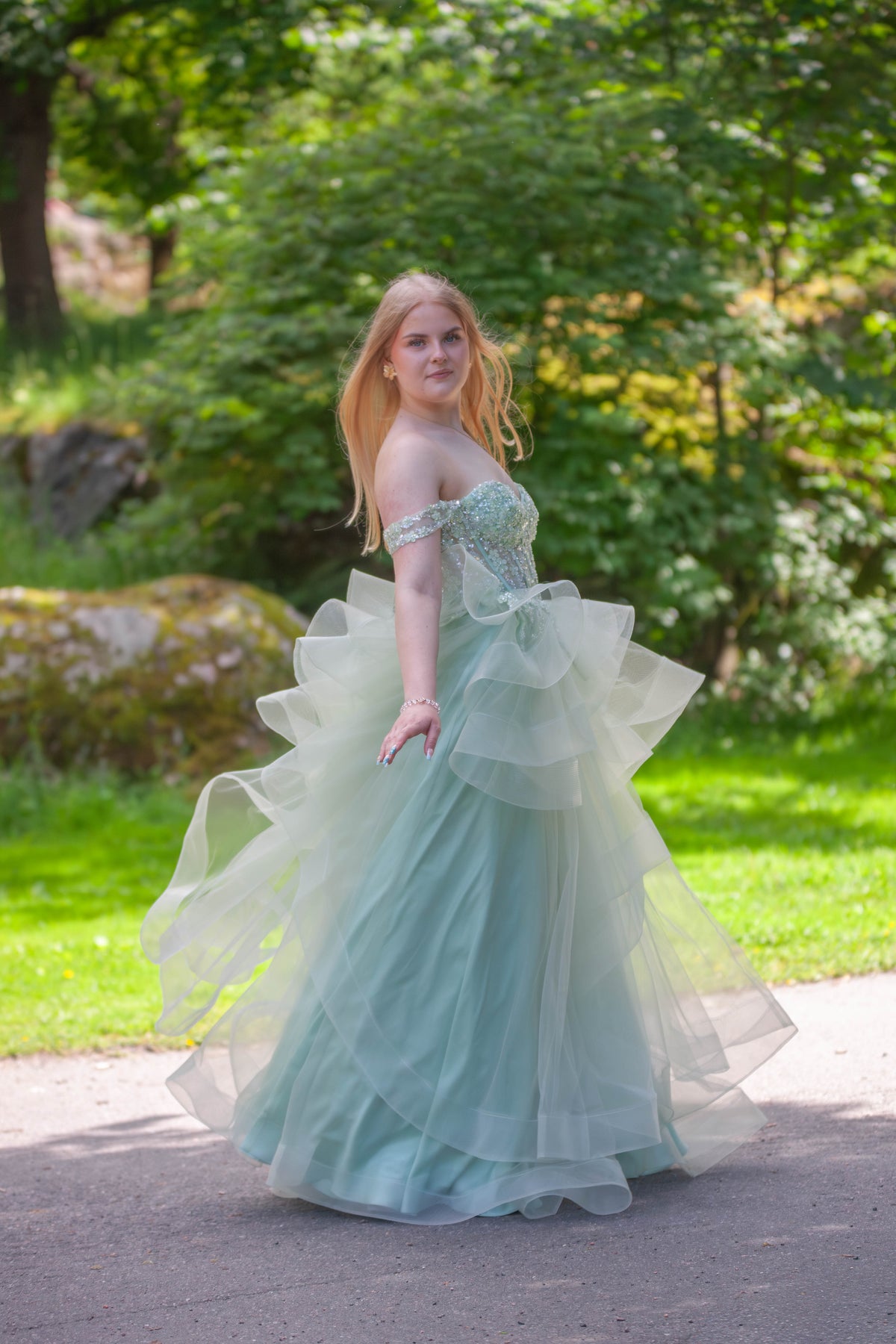 Vaaleanvihreä vanhojentanssimekko röyhelöhelmalla ja off shoulder -mallilla.
