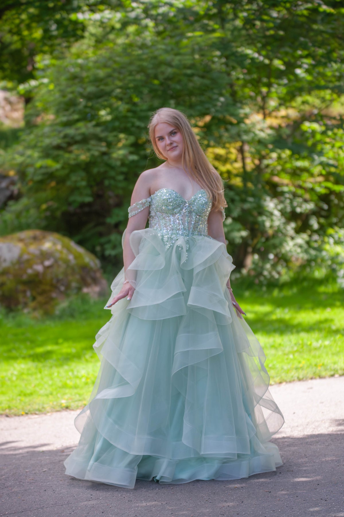 Vaaleanvihreä vanhojentanssimekko röyhelöhelmalla ja off shoulder -mallilla.