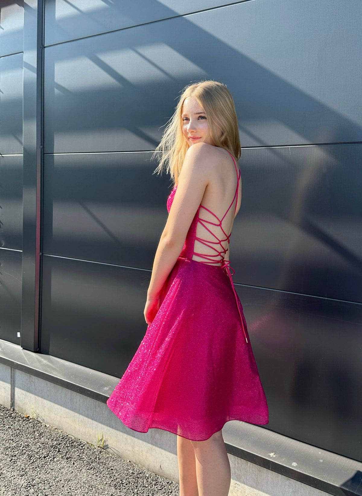 Kirkkaan pinkki kimaltava rippimekko.