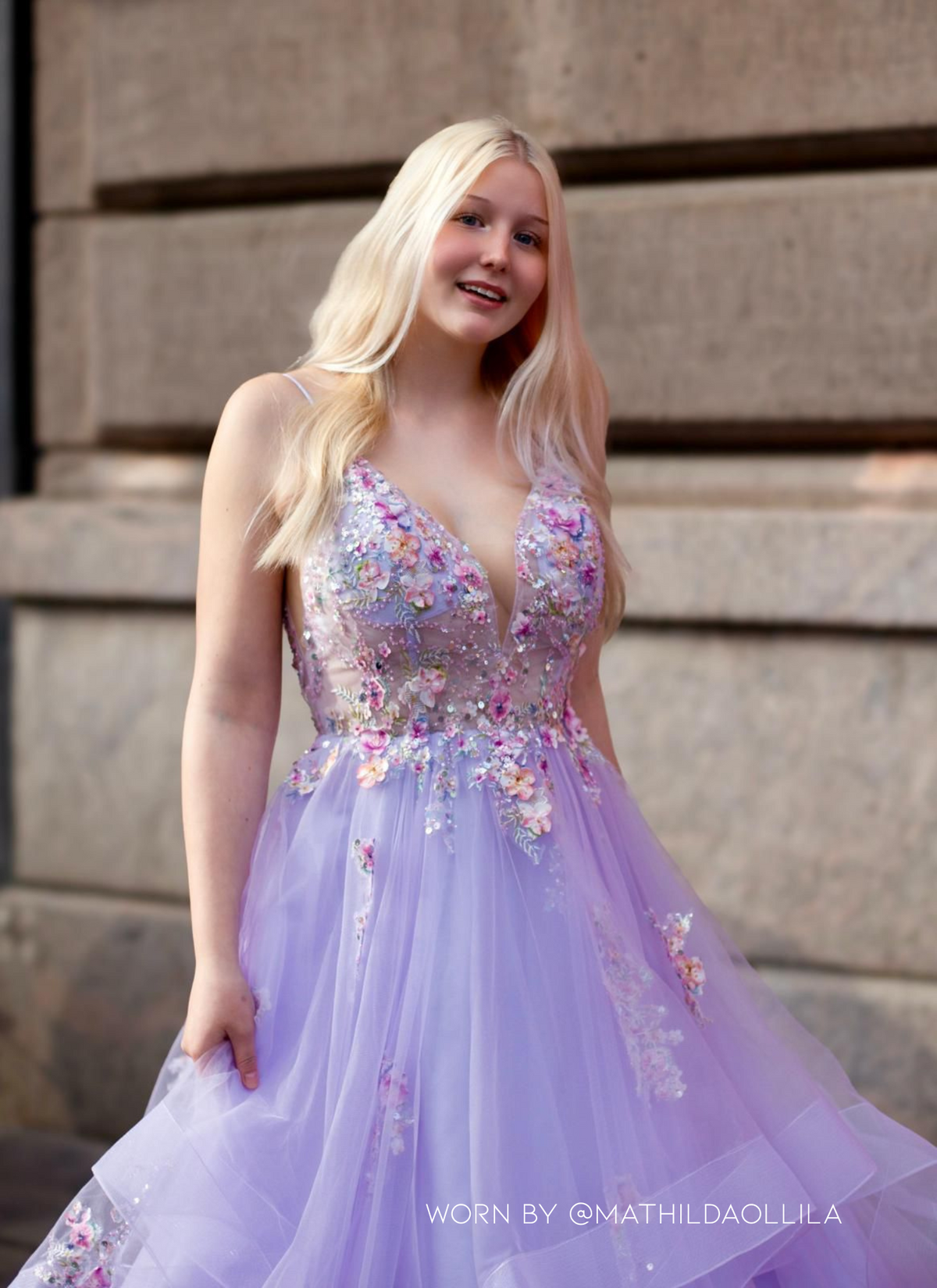 Violetti vanhojentanssimekko, kukkapitsillä ja röyhelöhelmalla, takaa.